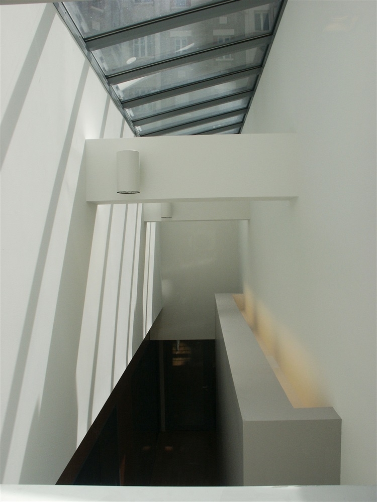 Vue depuis la salle de repos, lumière zénithale sur le couloir de distribution intérieur
